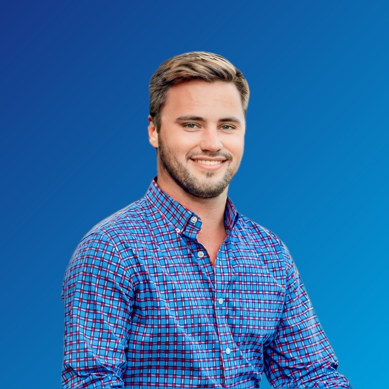 Portrait of Brentle Roberts smiling, wearing a blue plaid button-down shirt